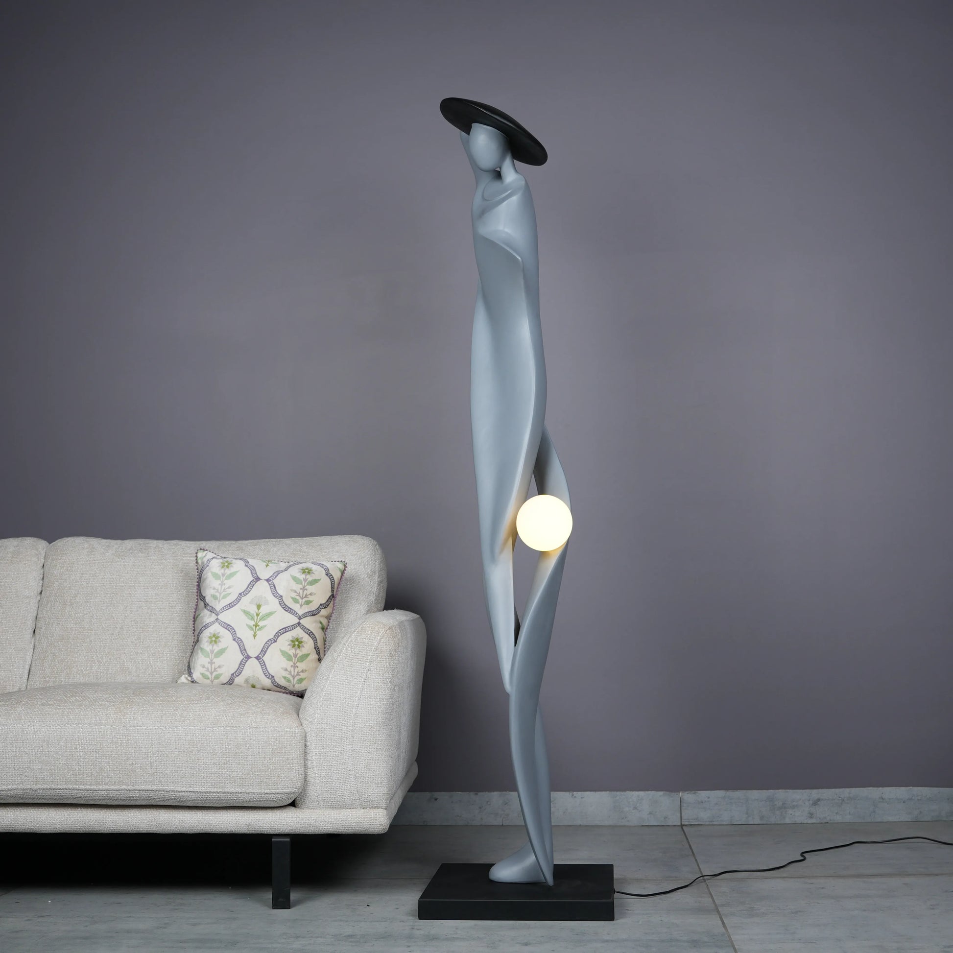 Bluish grey lady sculpture floor lamp with black hat and glowing orb – modern artistic lighting.
