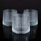 Crystal whiskey glasses with premium textured finish displayed on a wooden table in an elegant lounge atmosphere