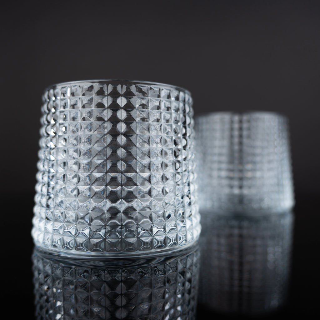 Modern whiskey drinkware set with detailed crystal texture and amber drink presentation in a luxury interior