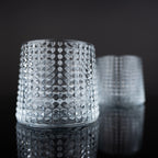 Modern whiskey drinkware set with detailed crystal texture and amber drink presentation in a luxury interior