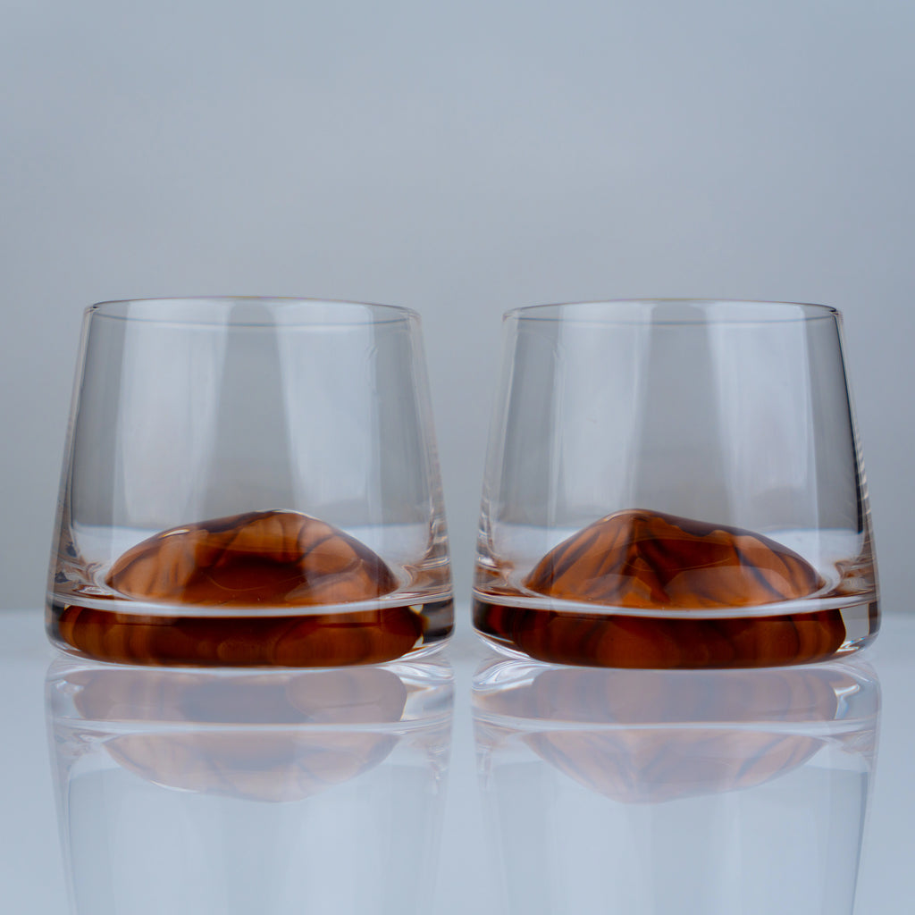 Luxury whiskey tumbler glasses with modern transparent finish and amber swirl detailing for elegant entertaining experiences