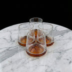 Contemporary whiskey tumbler glasses featuring artistic amber accents for premium barware and elegant entertaining arrangements