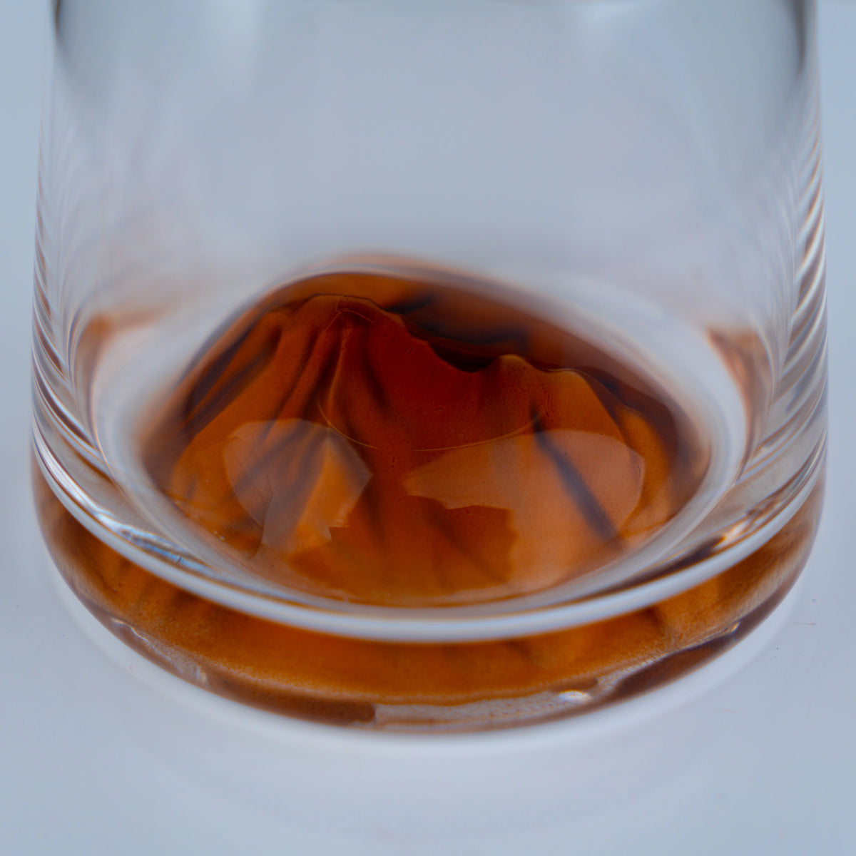 Modern crystal whiskey tumbler set featuring amber swirl base design for luxury tabletop and entertaining aesthetics