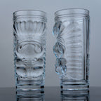 Two clear glass tumblers with intricate designs on a gray background