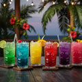 Colorful cocktails in glass tumblers on a wooden table with a tropical setting.