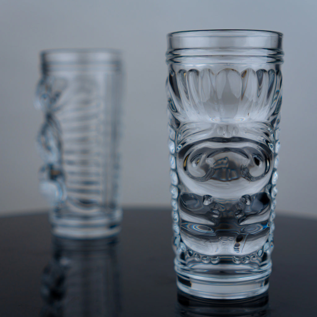 Tiki glasses pair, embossed face, dark surface