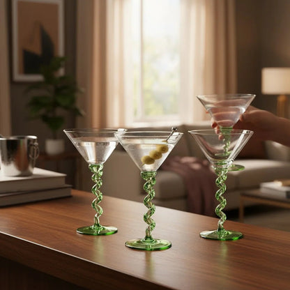 Three green spiral themed martini glasses on a wooden surface 