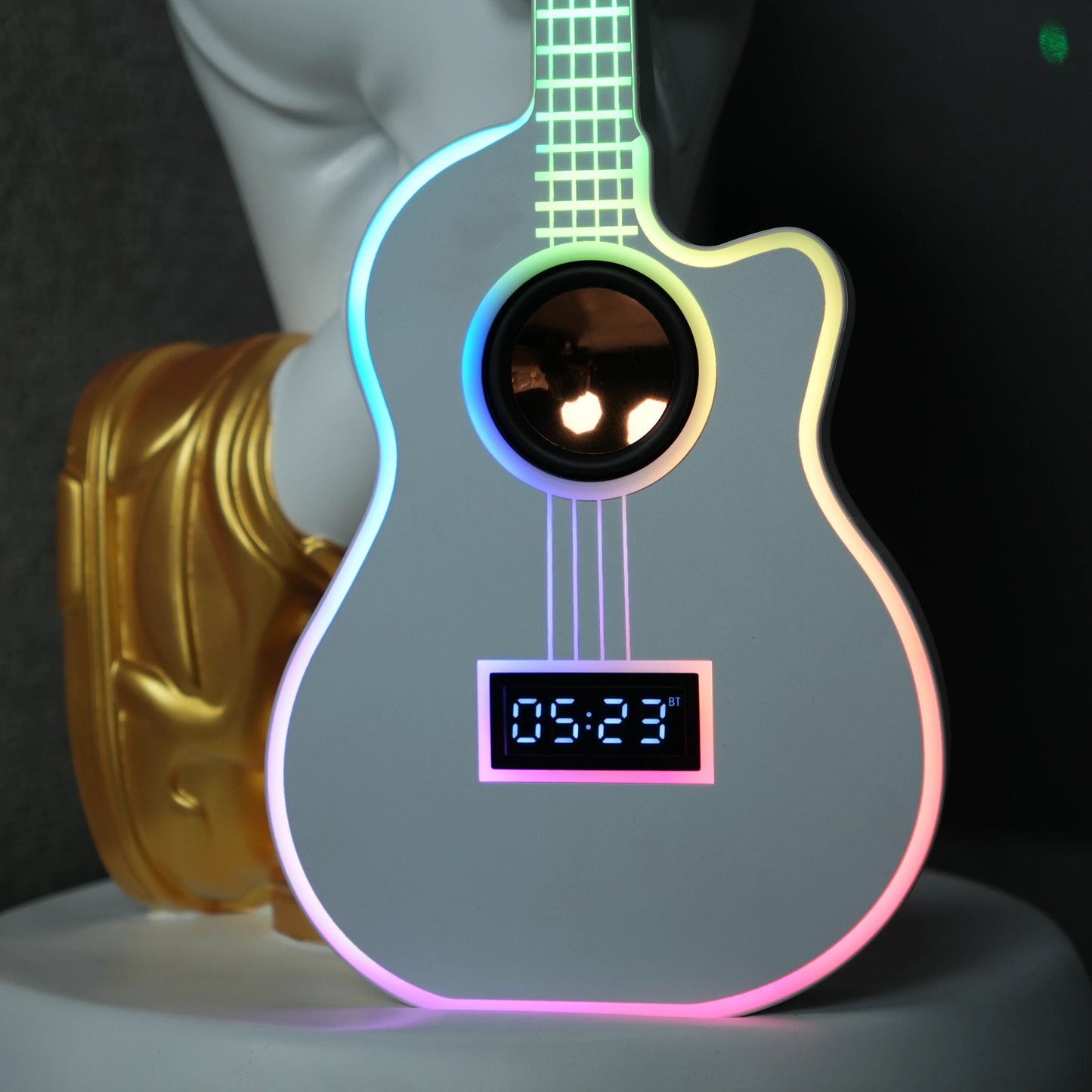 White-and-gold astronaut statue holding a moon projector balloon with a guitar-shaped Bluetooth speaker, standing on a pedestal with galaxy projection in the background.