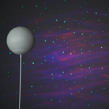 White-and-gold astronaut statue holding a moon projector balloon with a guitar-shaped Bluetooth speaker, standing on a pedestal with galaxy projection in the background.