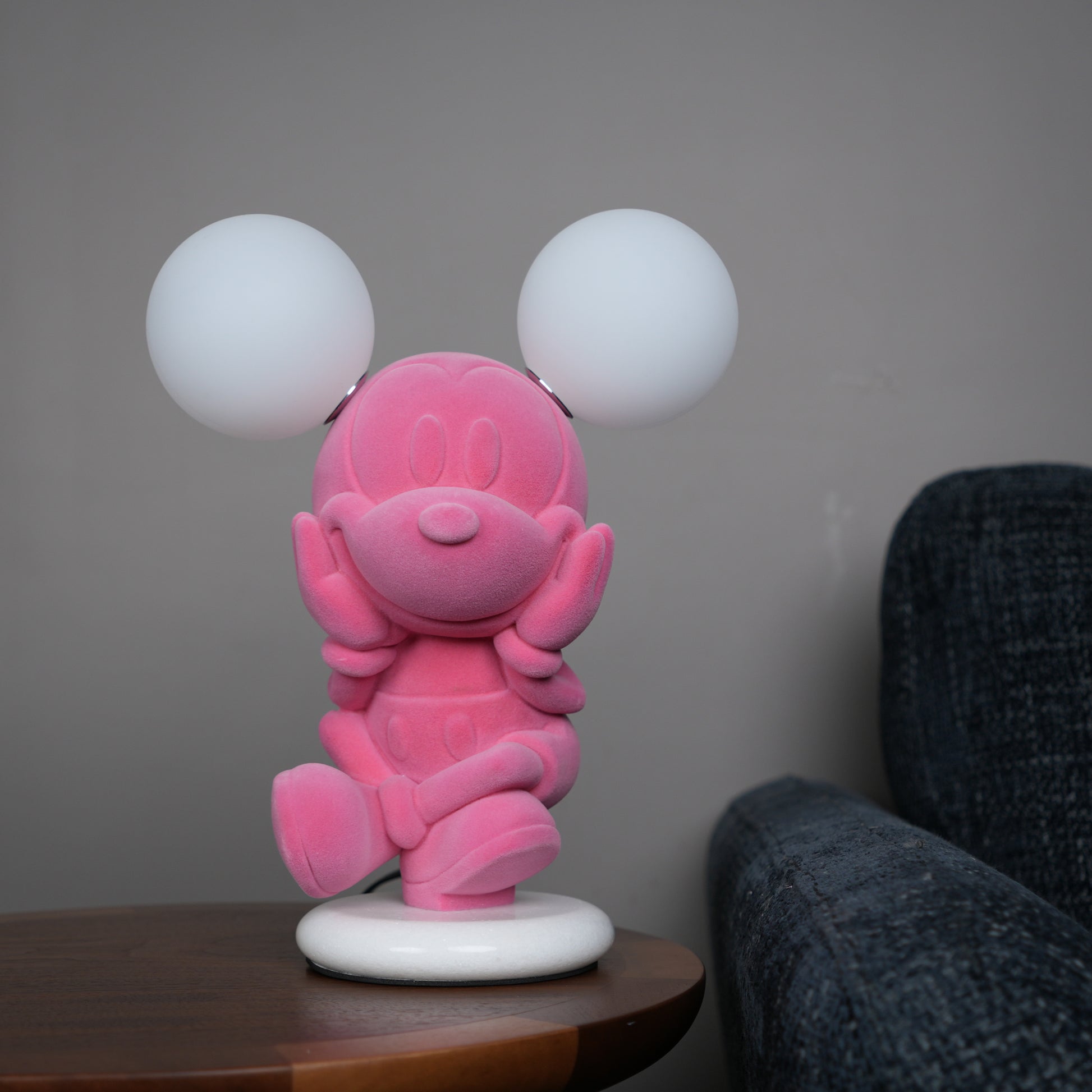 Pink figurine lamp with two warm glowing orb lights on top.