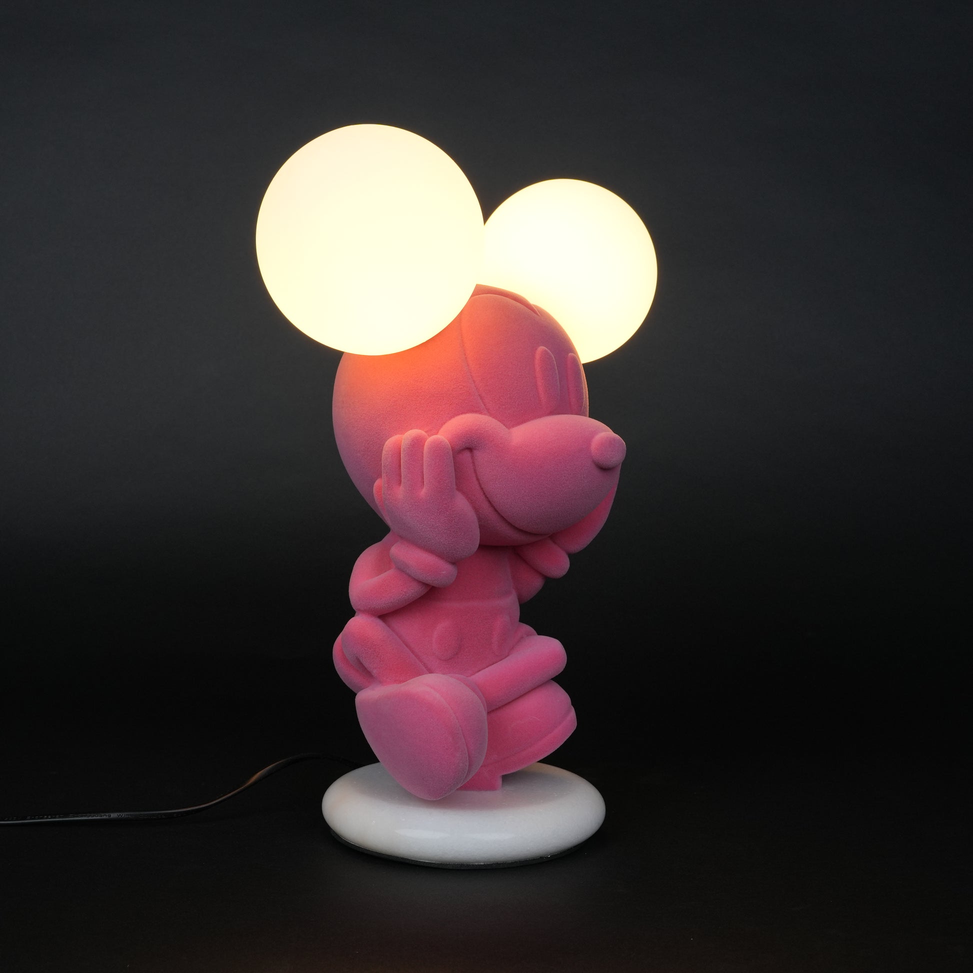 Pink figurine lamp with two warm glowing orb lights on top.