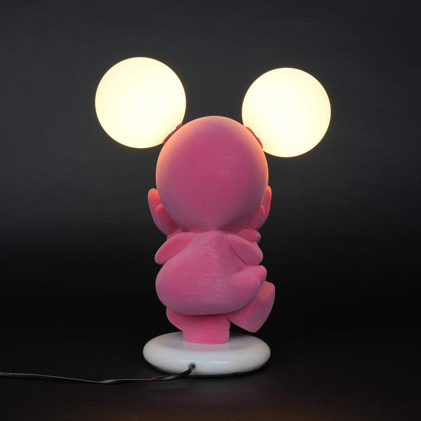 Pink figurine lamp with two warm glowing orb lights on top.