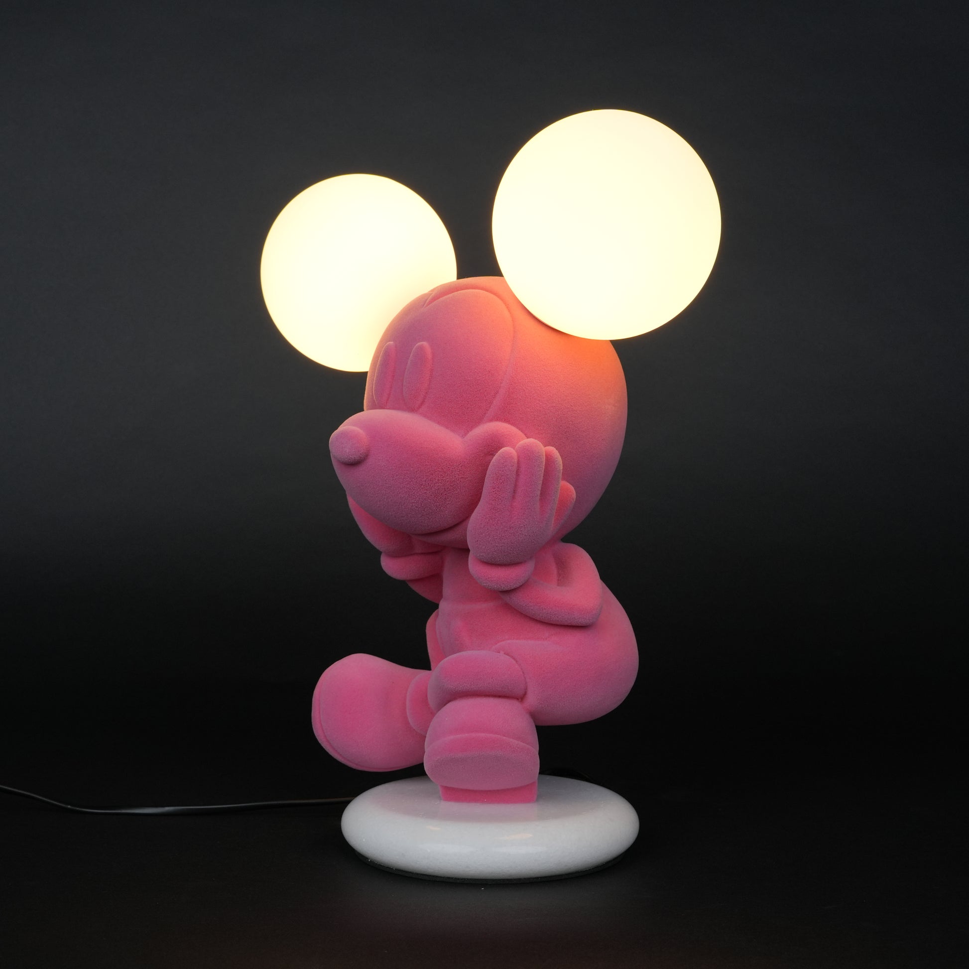 Pink figurine lamp with two warm glowing orb lights on top.