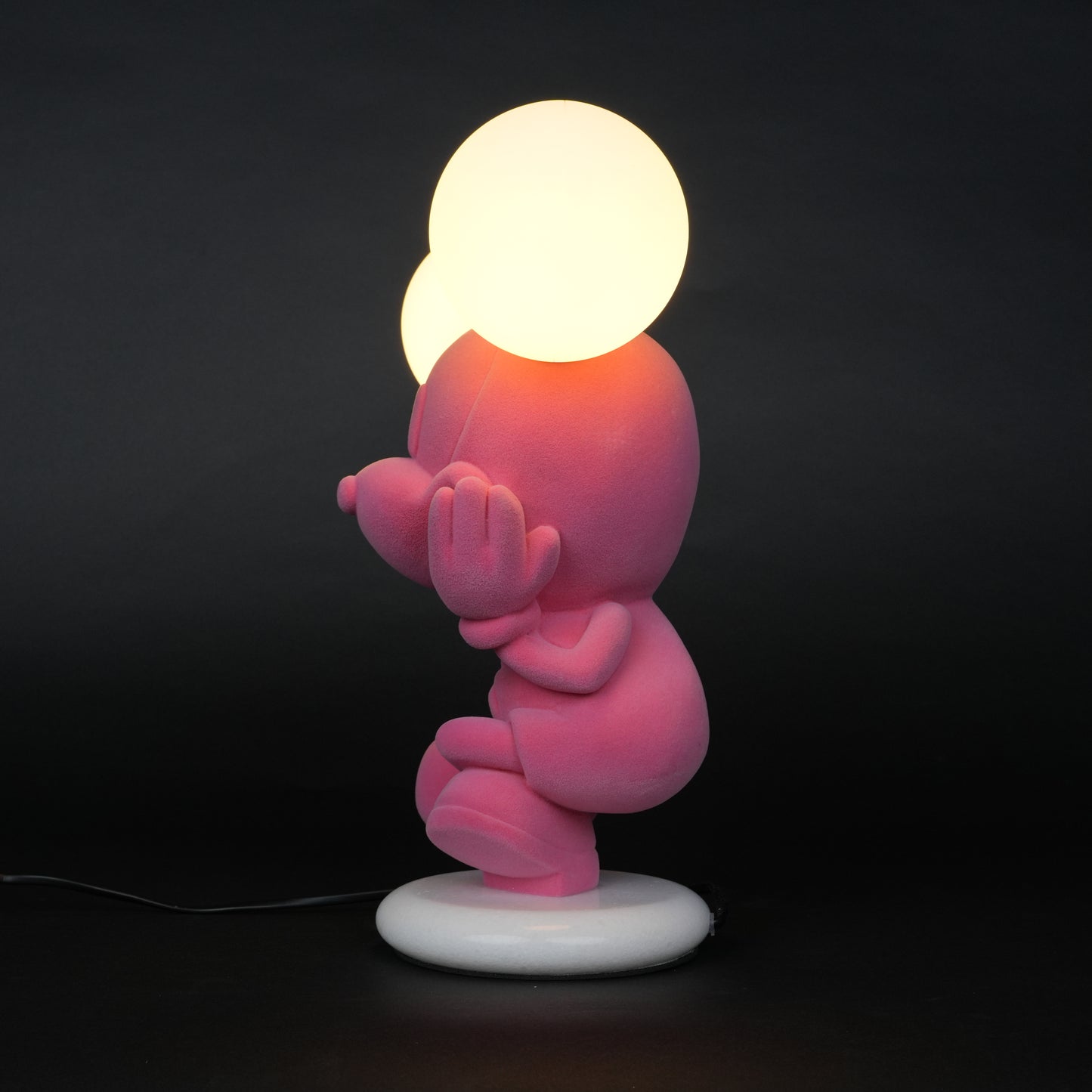 Pink figurine lamp with two warm glowing orb lights on top.