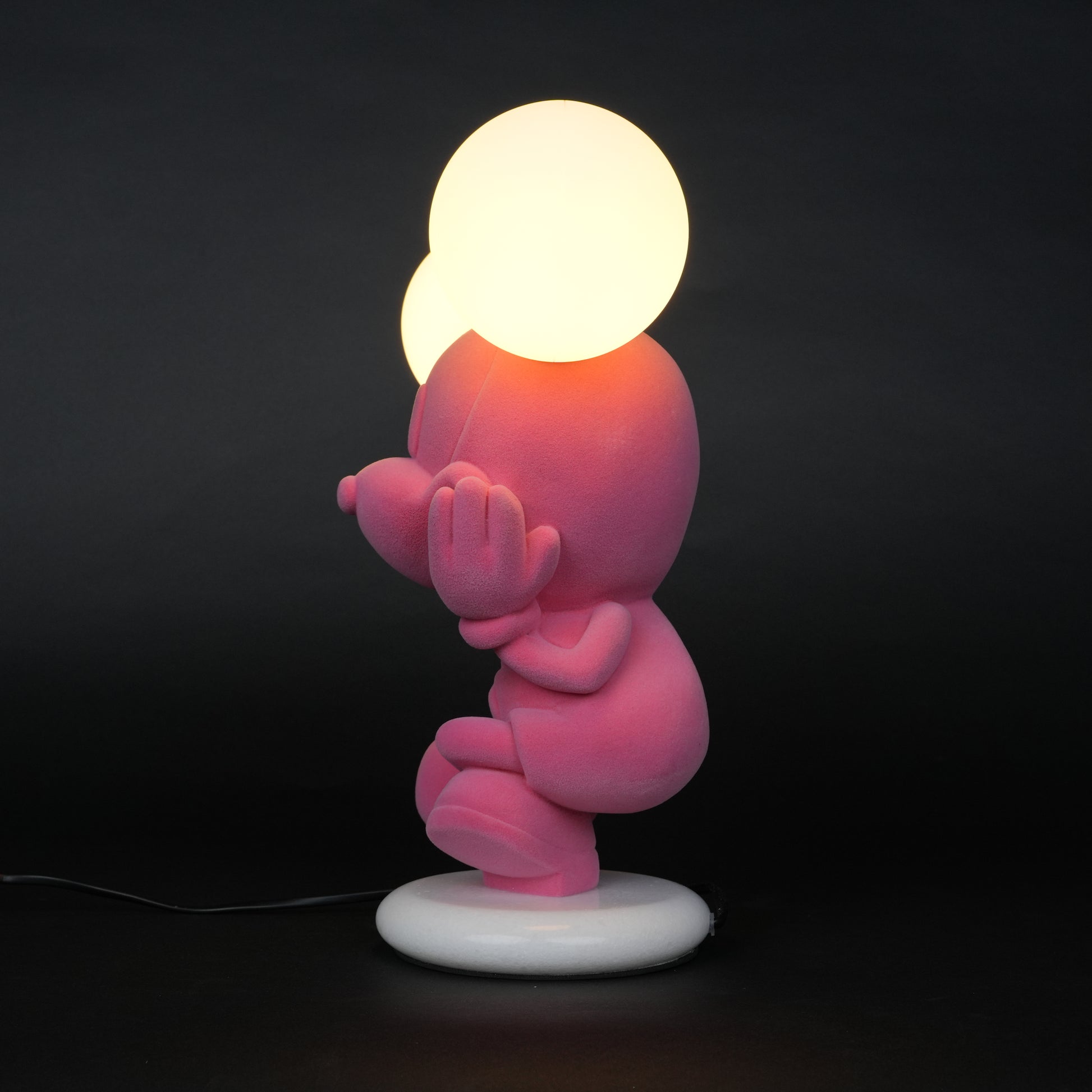 Pink figurine lamp with two warm glowing orb lights on top.