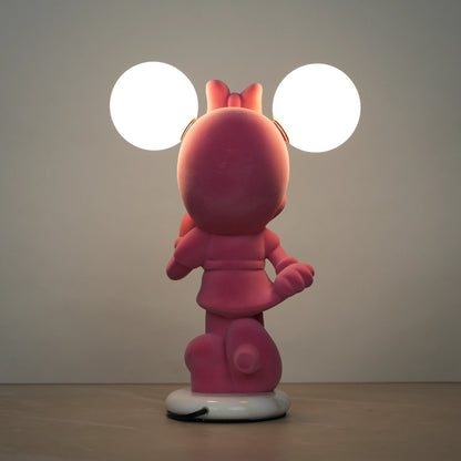 Standing pink flocked character lamp with two glowing ear-shaped bulbs on a white base.