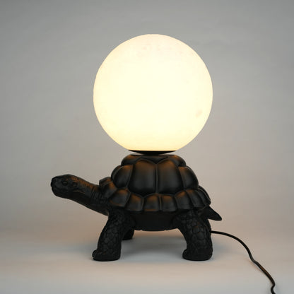 Black tortoise sculpture lamp with a glowing moon orb on its shell.