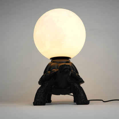 Black tortoise sculpture lamp with a glowing moon orb on its shell.