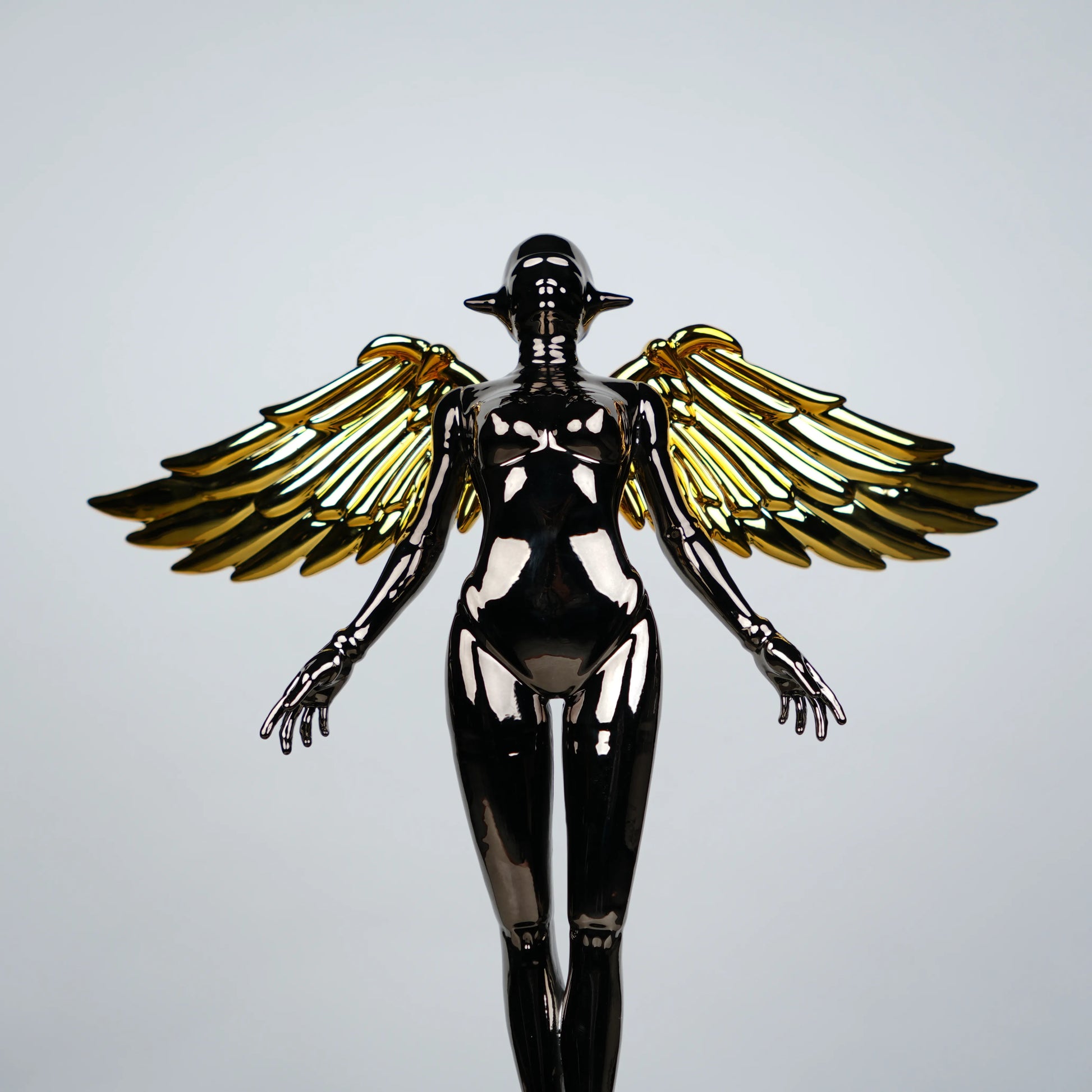 Celestial Chrome Angel Sculpture with reflective chrome body and gold wings on pedestal