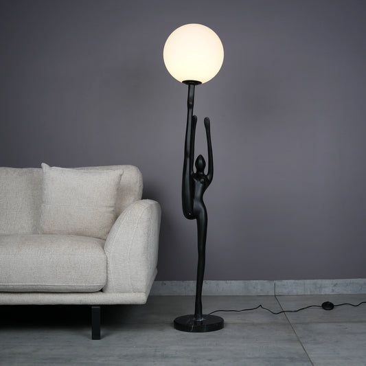 Elegant Human Stretch Lamp – tall matte black human-form sculpture holding a glowing orb floor lamp.