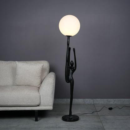 Elegant Human Stretch Lamp – tall matte black human-form sculpture holding a glowing orb floor lamp.