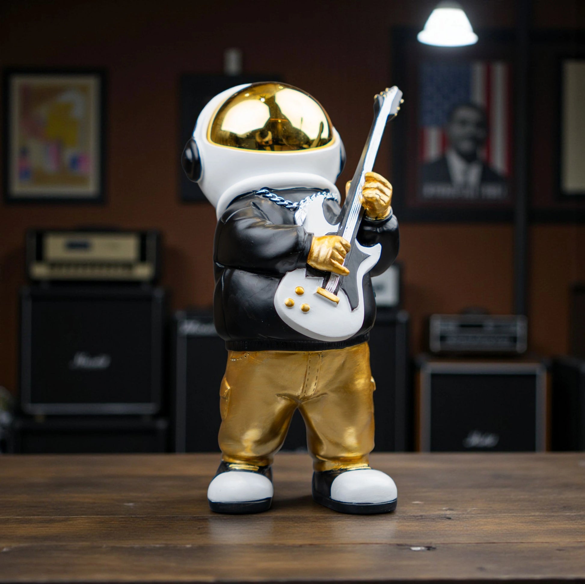 Small astronaut figurine playing guitar with gold helmet and metallic finish — Cosmic Rockstar Figurine by Ghar Art, handcrafted modern tabletop decor collectible.