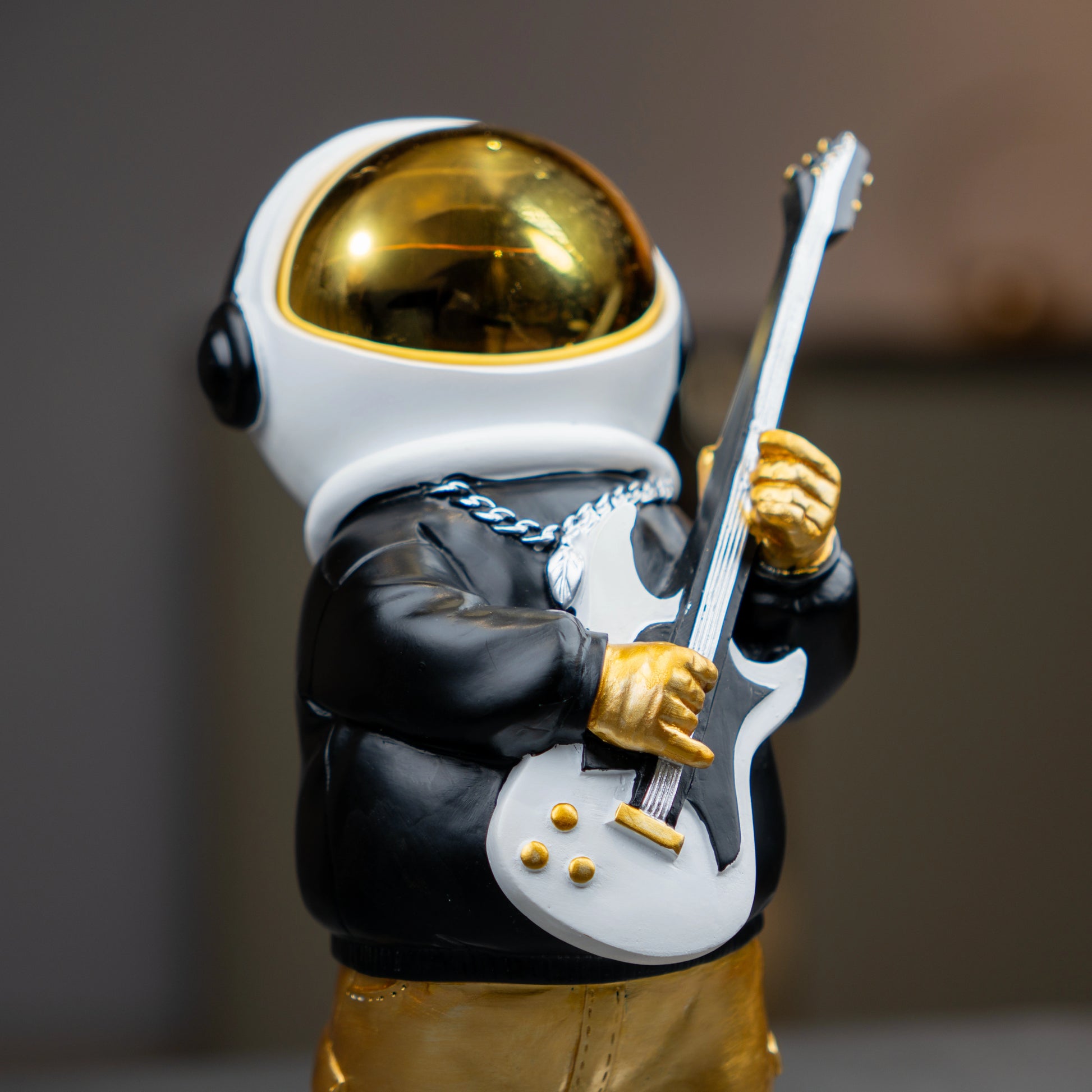 Small astronaut figurine playing guitar with gold helmet and metallic finish — Cosmic Rockstar Figurine by Ghar Art, handcrafted modern tabletop decor collectible.