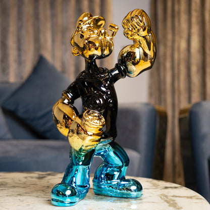 Aqua and gold metallic resin figurine in a dynamic pose — luxury high-gloss decorative sculpture by Ghar Art.