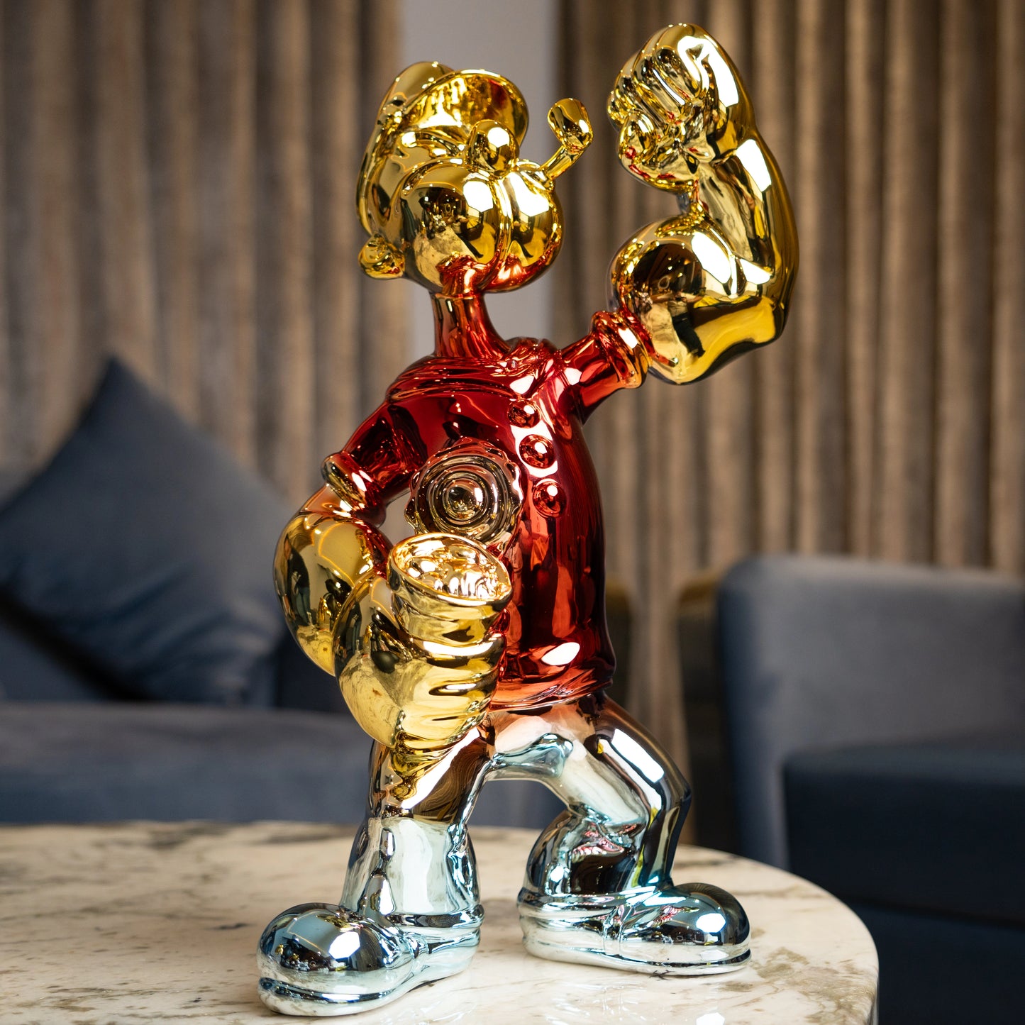 Red, gold, and silver metallic resin figurine in a dynamic pose — luxury electroplated decorative sculpture by Ghar Art.
