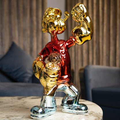 Red, gold, and silver metallic resin figurine in a dynamic pose — luxury electroplated decorative sculpture by Ghar Art.