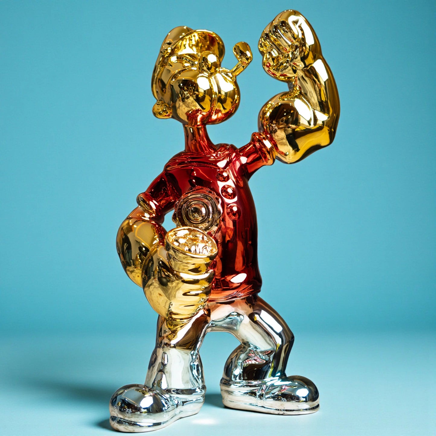 Red, gold, and silver metallic resin figurine in a dynamic pose — luxury electroplated decorative sculpture by Ghar Art.