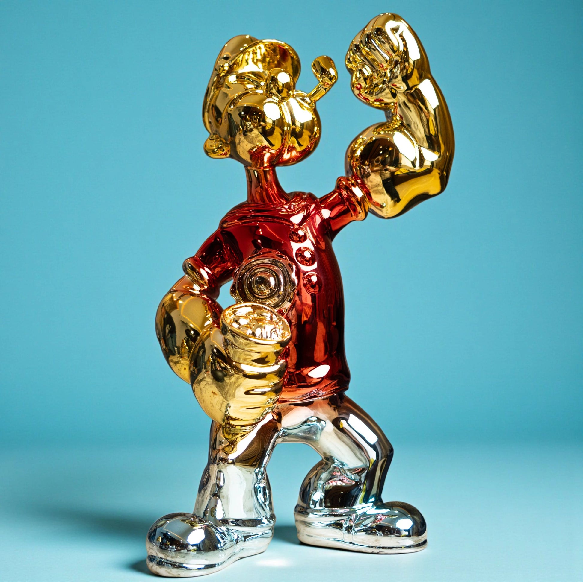 Red, gold, and silver metallic resin figurine in a dynamic pose — luxury electroplated decorative sculpture by Ghar Art.