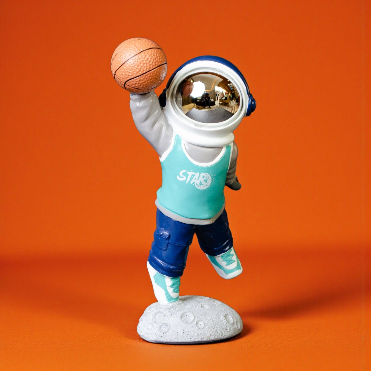 Astronaut figurine dribbling a basketball on a moon base with teal jersey and gold visor
