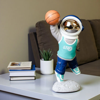 Astronaut figurine dribbling a basketball on a moon base with teal jersey and gold visor