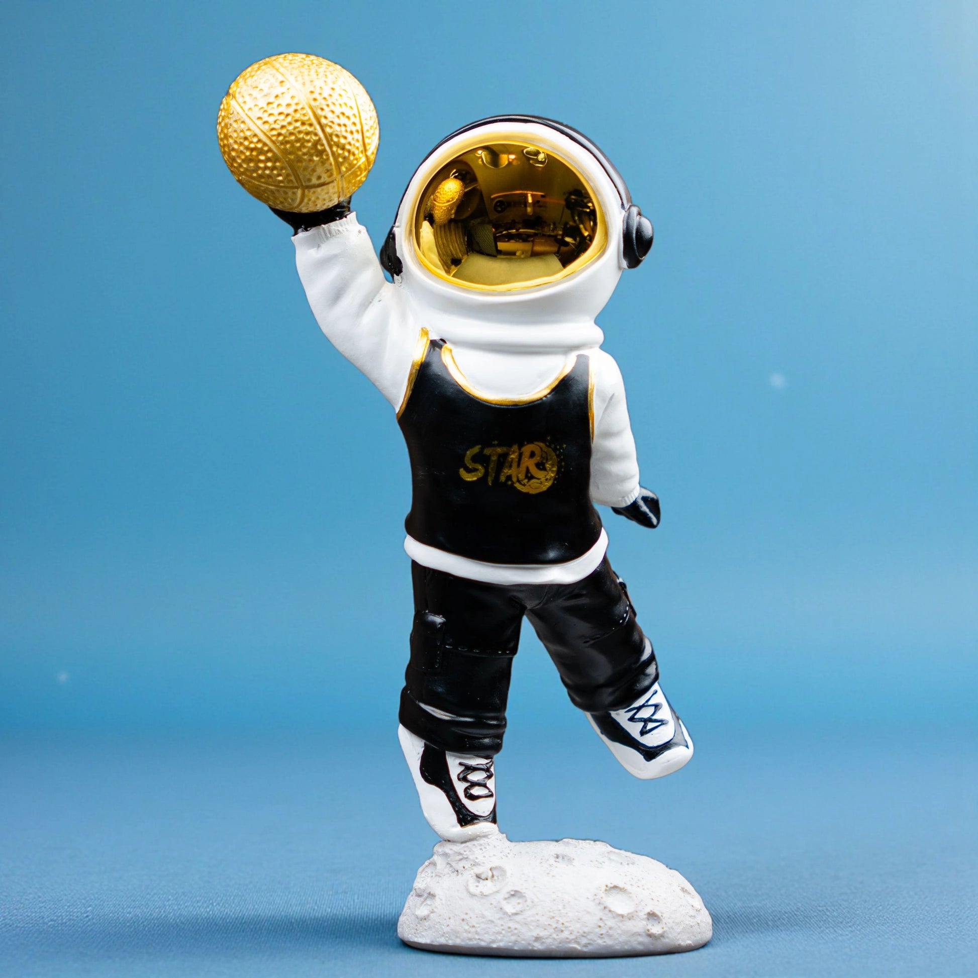 Astronaut figurine holding gold basketball, standing on moon-textured base — Cosmic Dunk Figurine by Ghar Art, handcrafted luxury modern tabletop decor collectible.