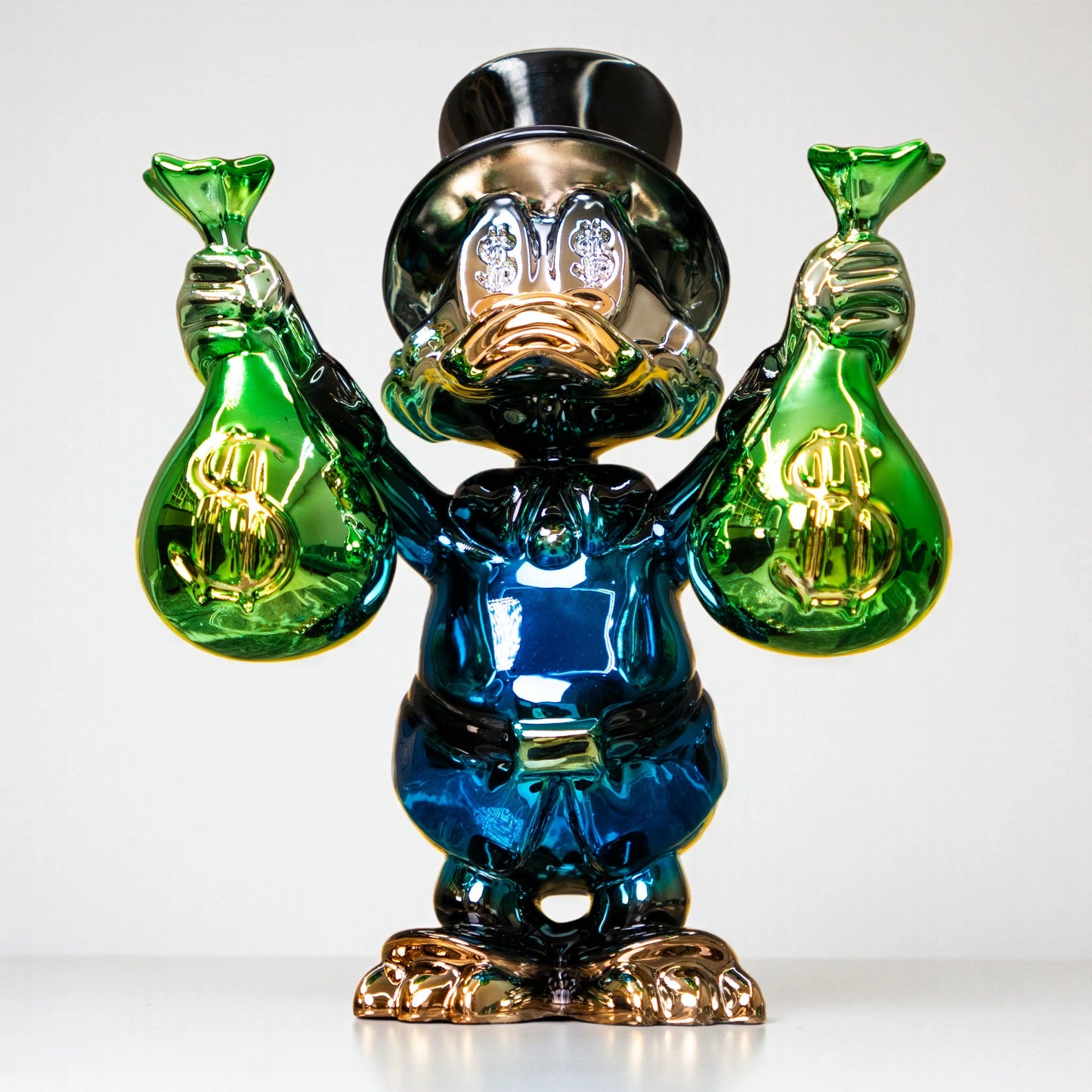 Metallic green and blue duck sculpture holding gold money bags — Money Maestro Sculpture by Ghar Art, handcrafted luxury pop-art collectible for modern decor.