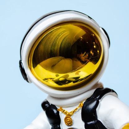 white cosmic skater astronaut figurine sitting on moon with skateboard