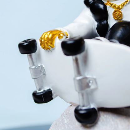 white cosmic skater astronaut figurine sitting on moon with skateboard