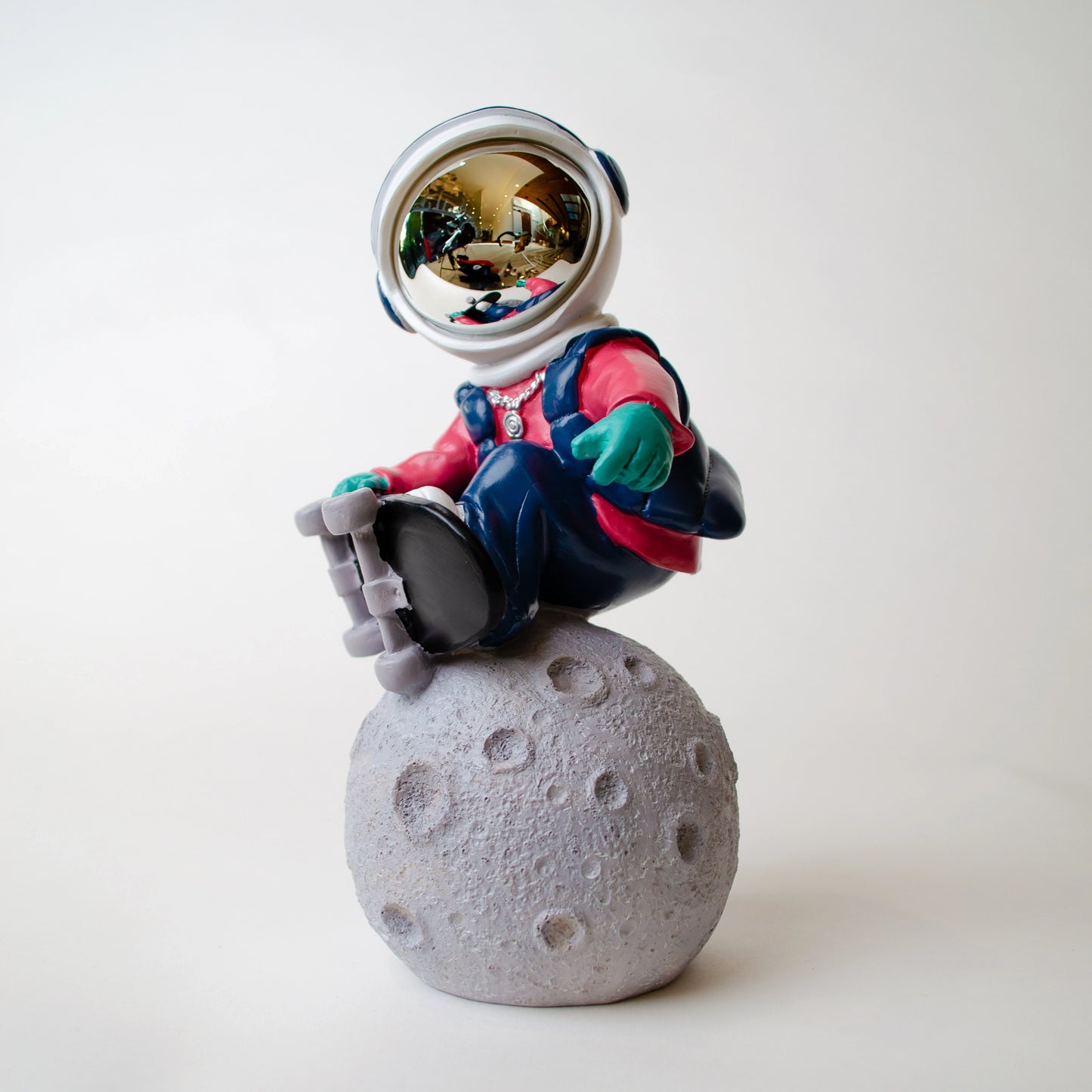 Astronaut skateboard figurine on moon base in multicolor resin