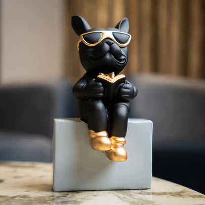 Black resin bulldog figurine trio with gold accents displayed on modern pedestal blocks