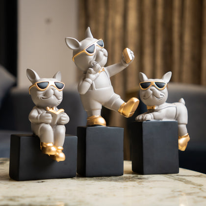 Set of three modern pop art dog figurines with sunglasses and gold accents on geometric bases, cartoon style tabletop decor for living room or office