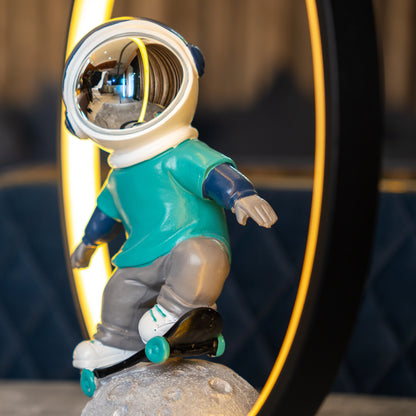 Astronaut skater lamp with teal suit, silver visor and LED ring on moon base
