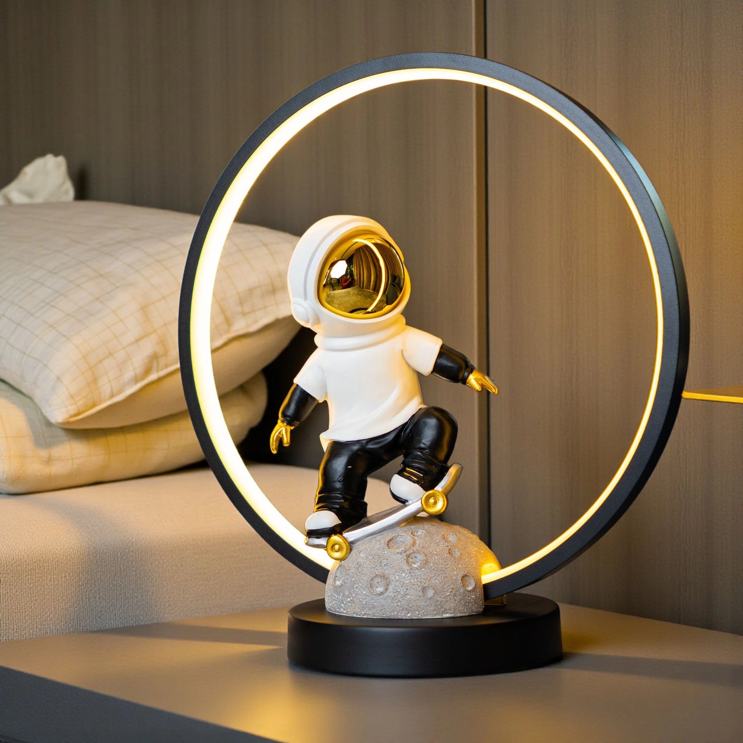 Astronaut skater lamp with white suit, gold visor and LED halo on grey moon base