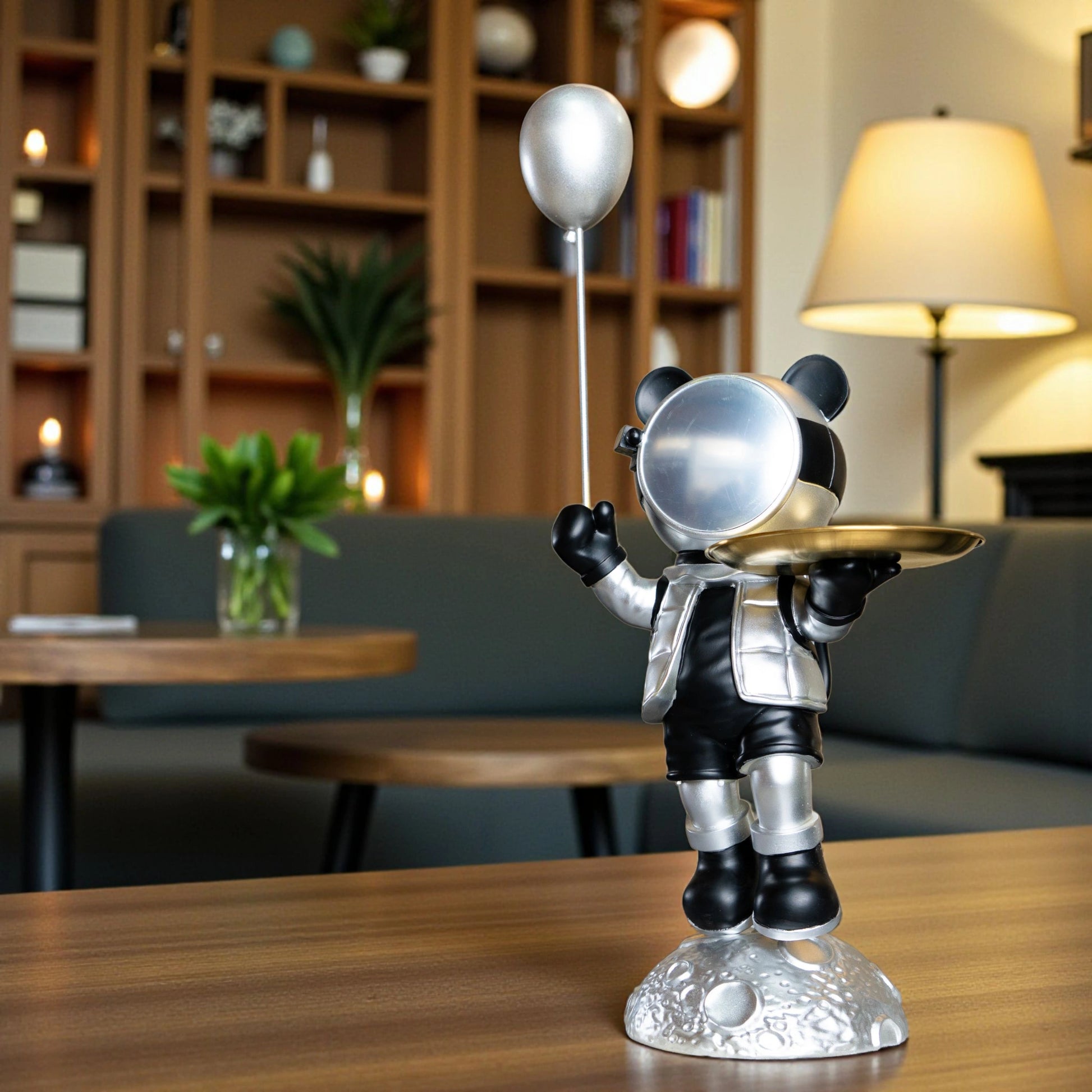 Astronaut bear figurine in silver and black holding a metallic balloon and a gold tray while standing on a moon-textured base; modern resin décor showpiece
