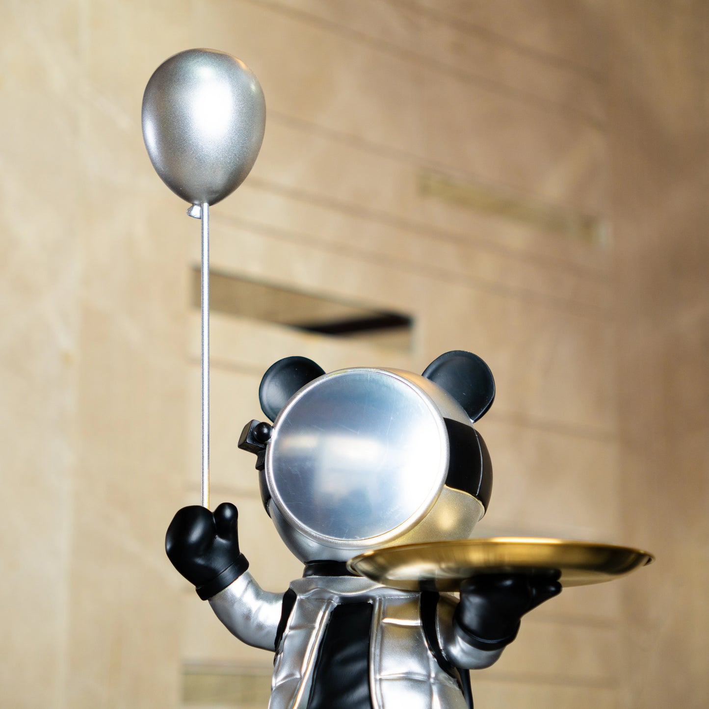Astronaut bear figurine in silver and black holding a metallic balloon and a gold tray while standing on a moon-textured base; modern resin décor showpiece