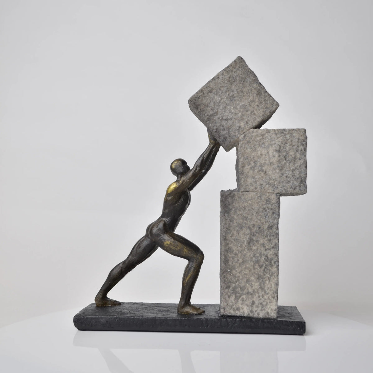 Vertical bronze human sculpture pulling sphere on stepped textured base