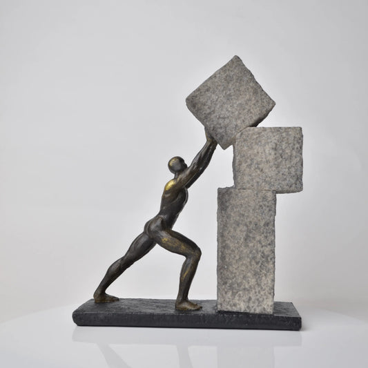 Vertical bronze human sculpture pulling sphere on stepped textured base