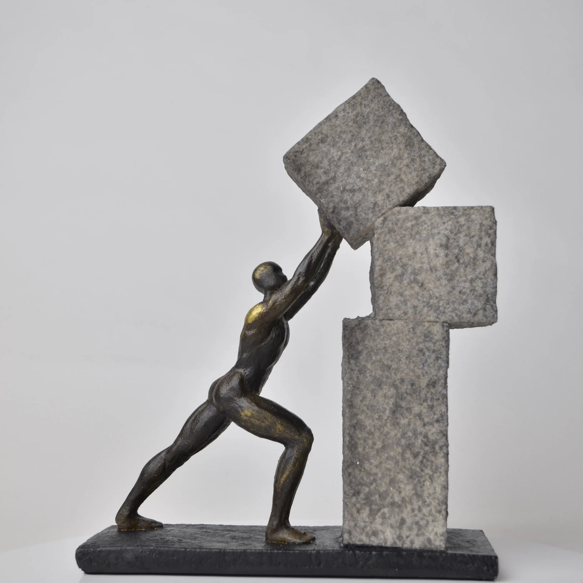 Vertical bronze human sculpture pulling sphere on stepped textured base