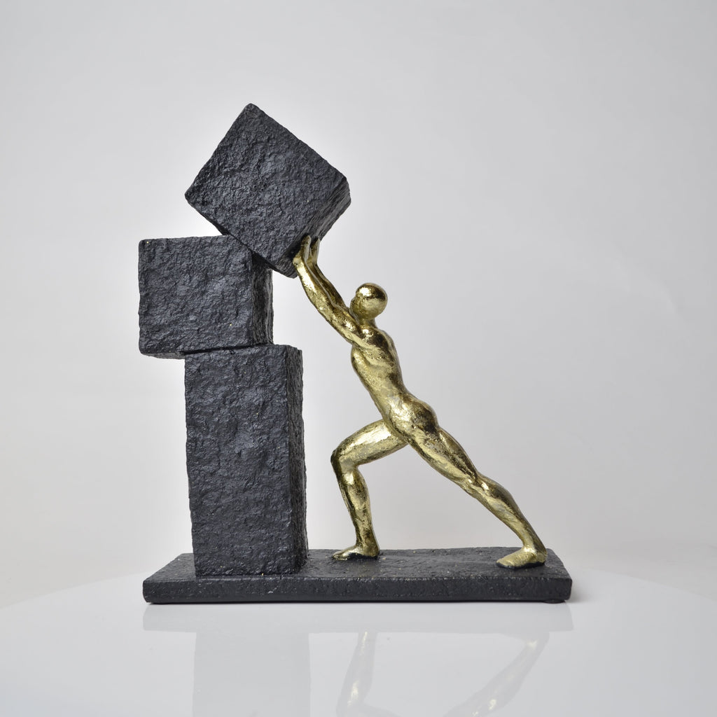 Vertical gold human struggle sculpture pulling textured sphere on stepped base