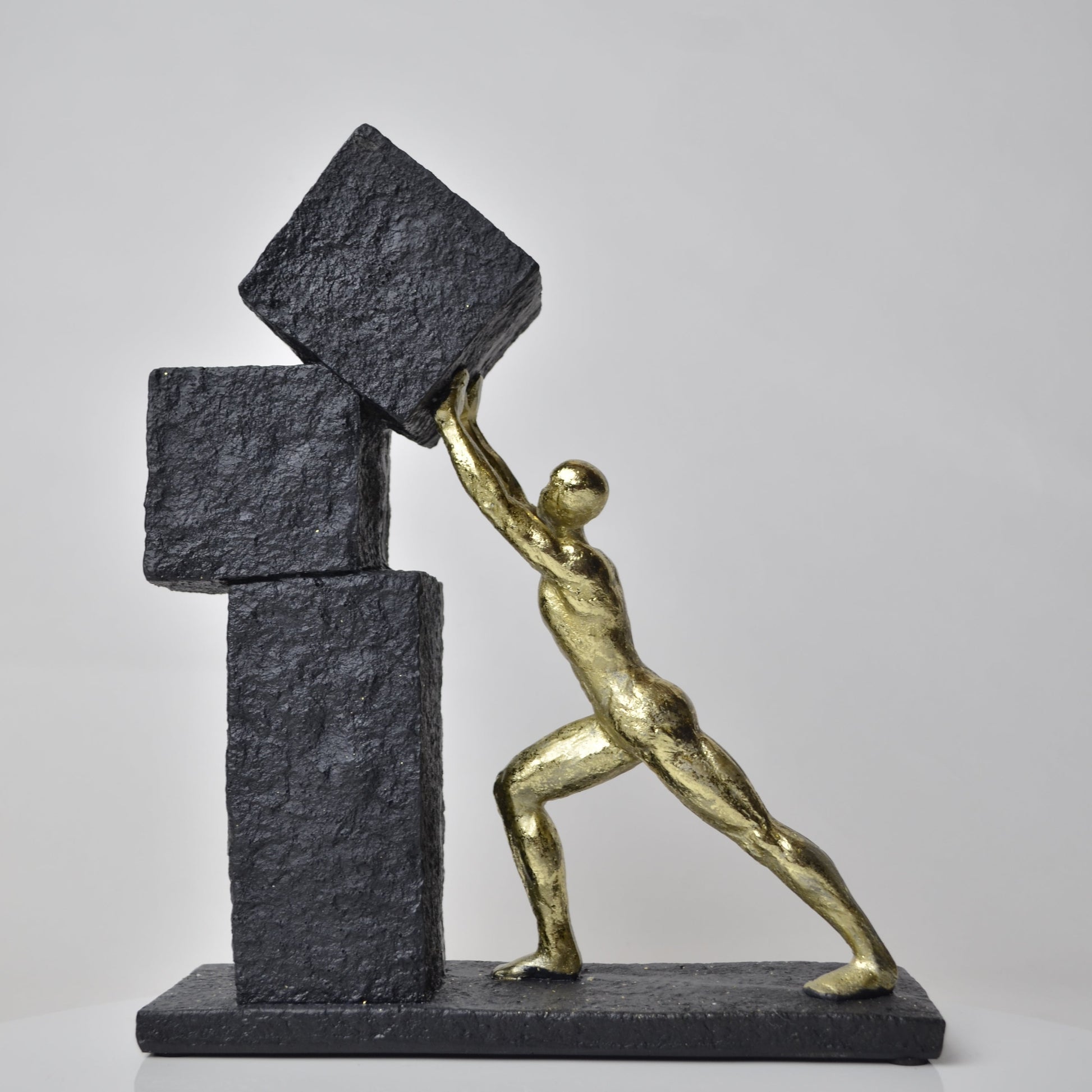 Vertical gold human struggle sculpture pulling textured sphere on stepped base